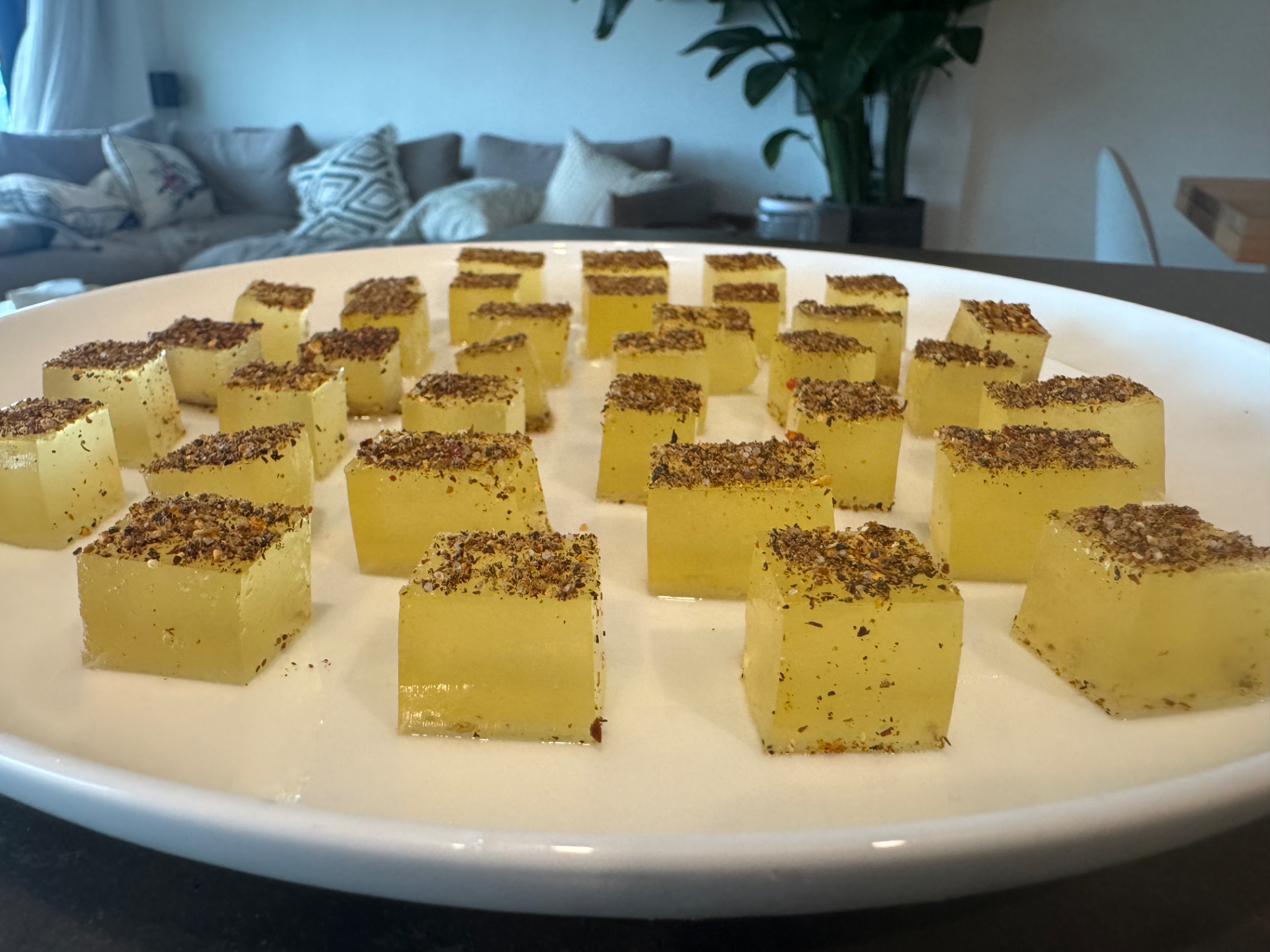 Pale amber mezcal margarita wine gum cubes dusted with Tajín, arranged on a white platter
